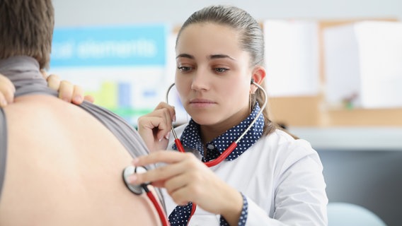 Eine junge Ärztin hört einen Patienten mit einem Stethoskop ab. © Colourbox 