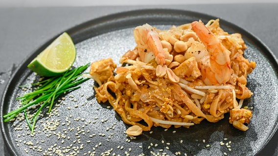Asiatische Reisnudelpfanne mit Garnelen auf einem Teller angerichtet. © NDR / Die Fernsehmacher Foto: Markus Hertrich