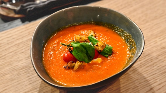 Tomaten-Basilikum-Suppe mit Croûtons in einer Schale angerichtet. © NDR/Fernsehmacher GmbH Foto: Markus Hertrich