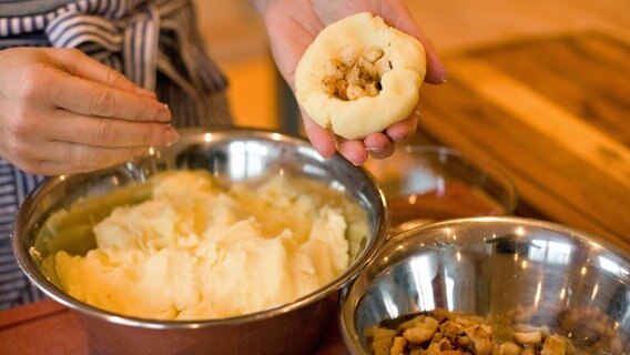 Ein Koch füllt Knödel mit gerösteten Weißbrotwürfeln © NDR Foto: Claudia Timmann