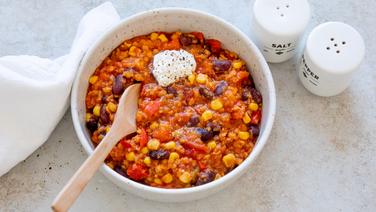 Eine Schale mit Chili sin carne, darauf ein Klecks saure Sahne. © NDR Foto: Claudia Timmann