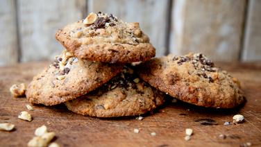 Cookies aus Buchweizenmehl mit Nüssen und Schokostückchen liegen auf einem Holztisch. © NDR Foto: Claudia Timmann