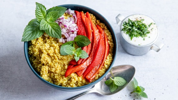 Eine Schale mit Couscous und Gemüse, dazu ein Glas mit Minzjoghurt. © NDR Foto: Claudia Timmann