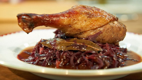 Entenkeule mit Rotkohl und Soße auf einem Teller serviert. © NDR Foto: M. Haupt