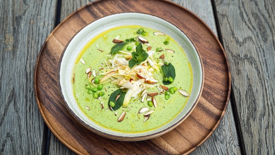 Kalte Erbsensuppe mit Chicorée-Apfelsalat auf einem Teller angerichtet. © NDR Foto: Tarik Rose