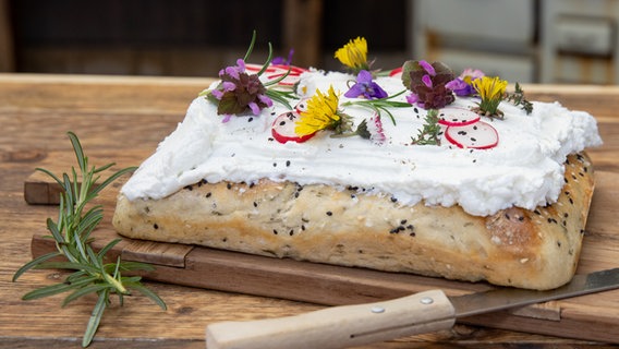 Kräuter-Fladenbrot mit Ziegenfrischkäse bestrichen. © NDR Foto: Claudia Timmann