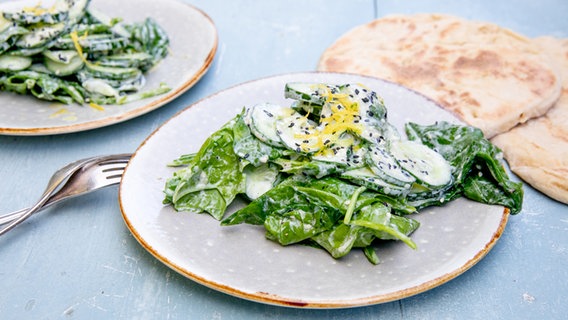 Gurken-Spinatsalat mit Joghurt und Sesam auf einem Teller serviert. © NDR Foto: Claudia Timmann