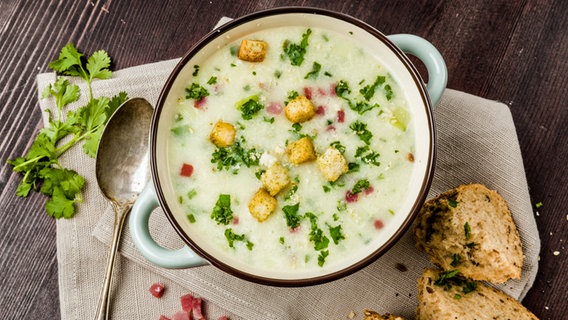 Kartoffelsuppe mit Speck, Kräutern und Croûtons in einer Suppenschale serviert. © IMAGO/Shotshop Foto: imago images