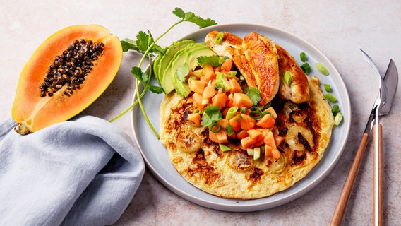 Ein Teller mit einem Omelett, serviert mit Avocado, Hähnchen und Papaya. © NDR Foto: Claudia Timmann