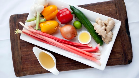 Paprikaschoten, Rhabarber, Zwiebeln, eine Salatgurke und Gewürze auf einer Platte. © NDR Foto: Claudia Timmann