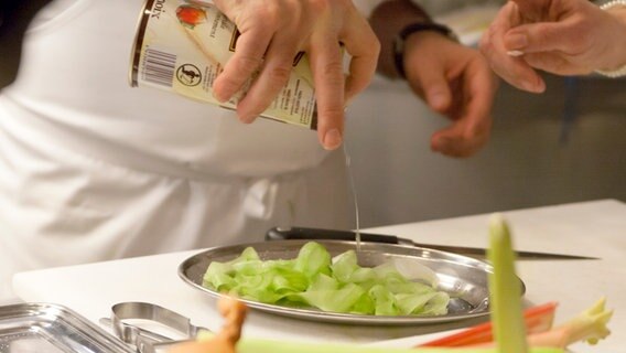 Ali Güngörmüs mariniert gehobelte Salatgurke mit Öl. © NDR Foto: Claudia Timmann