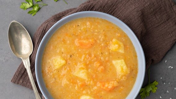 Eine Schüssel wärmende Kartoffelsuppe steht essbereit auf dem Tisch. © Colourbox 