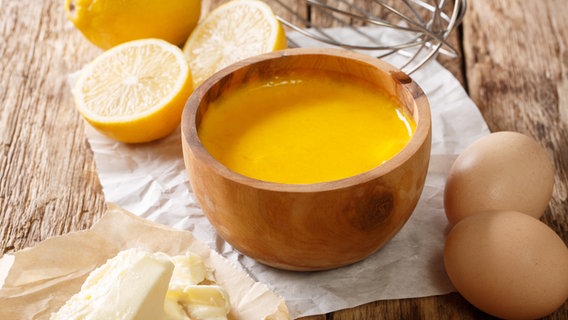 Eine Sauce hollandaise in einer kleinen Schale, daneben Eier, Zitrone und Butter sowie ein Rührbesen. Eine Sauce hollandaise in einer kleinen Schale, daneben Eier, Zitrone und Butter sowie ein Rührbesen. © Colourbox