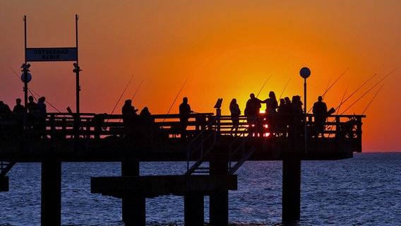 Angler im Sonnenuntergang auf der Seebrücke in Rerik. © Picture-Alliance / dpa Foto: Christian Charisius