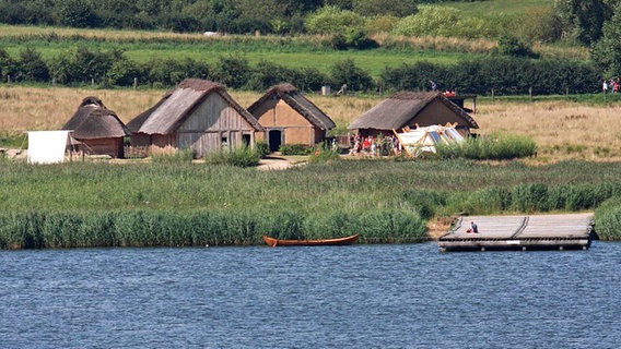 Die rekonstruierte Siedlung und der Landesteg in Haithabu vom Wasser aus gesehen. © Stiftung Schleswig-Holsteinische Landesmuseen 