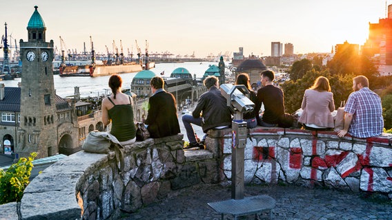 Menschen sitzen auf einer Aussichtsplattform oberhalb der Hamburger Landungsbrücken © www.mediaserver.hamburg.de Foto: Jörg Modrow