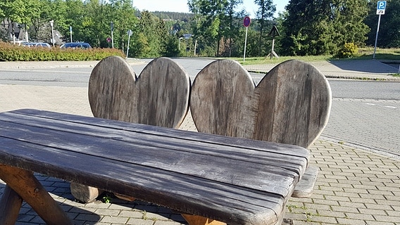 Eine Holzbank mit Rückenlehnen in Herzform am Liebesbankweg in Hahnenklee. © NDR Foto: Kathrin Weber