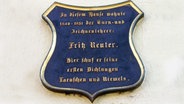 Blaues Wappen zum Gedenken an Fritz Reuter an seinem ehemaligen Wohnhaus in Altentreptow. © CC-BY-SA 3.0 Foto: Dreizung