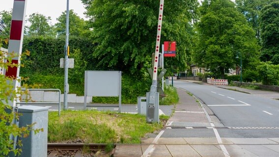 Schranken, Schienen und ein Hinweisschild mit der Aufschrift "Achterwehr" am Bahnhof. © NDR Foto: Anja Deuble