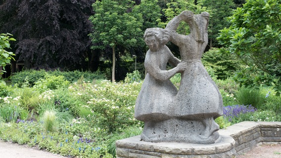 Eine Skulptur aus Muschelkalk zeigt zwei tanzende Mädchen im Hamburger Stadtpark. © NDR Foto: Anja Deuble