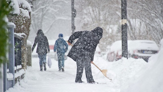 Eine Frau befreit einen Gehweg vor ihrem Wohnhaus vom Schnee. © picture alliance / dpa Themendienst Foto: Tobias Hase