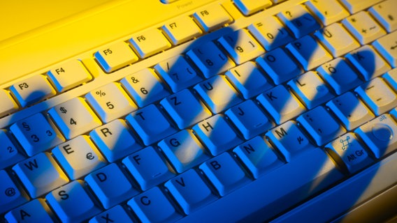 Computer-Tastatur mit Schatten einer Hand © Colourbox Foto: -