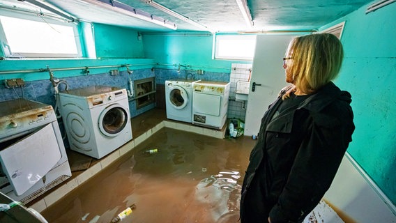 Ein Flutopfer in Nordrhein-Westfalen begutachtet den Wasserschaden in ihrem Mietshaus. © Picture-Alliance/ dpa / Markus Klümper 