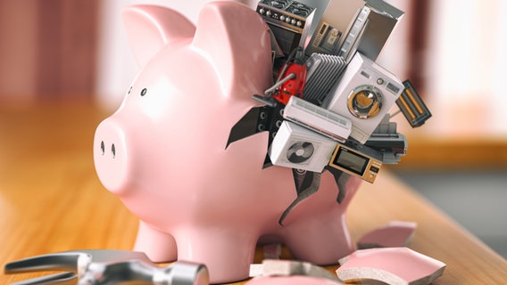 Ein Sparschwein mit verschiedenen elektrischen Geräten im Kleinformat. © Imago Images / easyFotostock Foto:  MaksymxYemelyanov