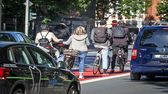 Radfahrer stehen an einer Ampel zwischen Autos. © imago images / Rüdiger Wölk 