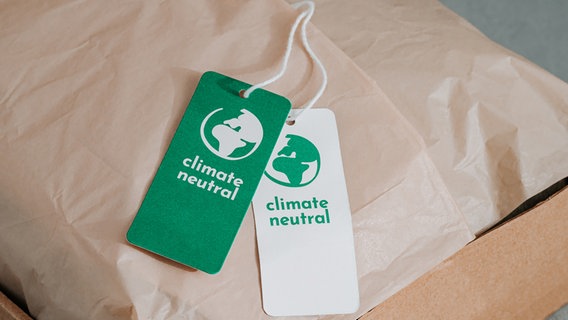 Zwei Anhänger mit der Aufschrift "climate neutral" an einem Paket. © Colourbox Foto: Stock-Foto