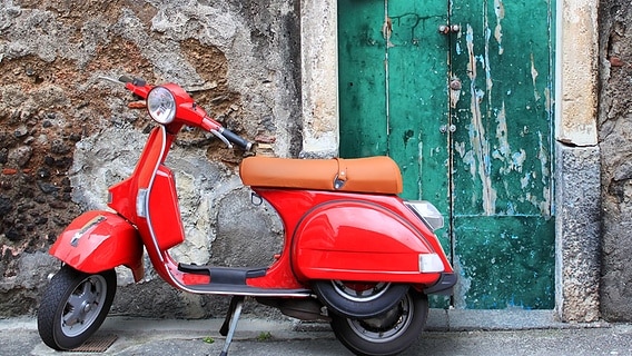 Ein roter Motorroller steht vor einer alten, grünen Haustür. © colorbox Foto: #7000