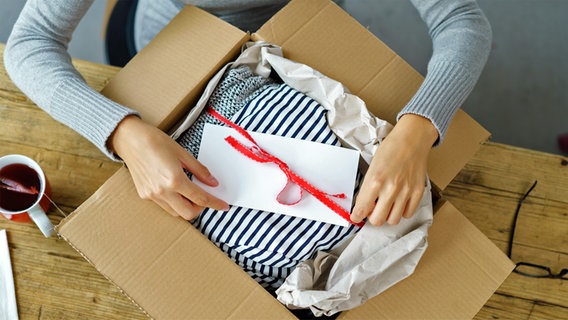 Eine Frau packt ein Päckchen. © fotolia Foto: contrastwerkstatt
