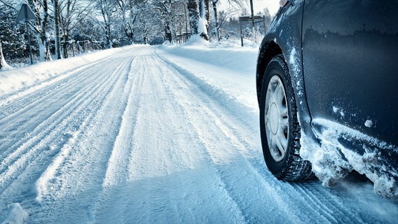 Ein Auto fährt auf einer verschneiten Straße. © fotolia Foto: candy1812