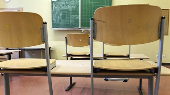 In einem Klassenraum stehen die Stühle auf den Tischen. © imago images / stpp 