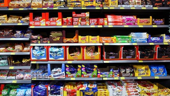 Ein Regal mit vielen verschiedenen Schokoladensorten und anderen Süßigkeiten in einem Supermarkt. © picture alliance / imageBROKER | Jochen Tack Foto: Jochen Tack