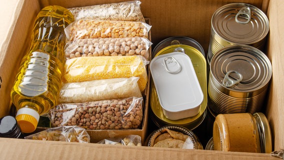 Verschiedene Lebensmittel für den Notfall-Vorrat in einem Karton © picture alliance / Zoonar Foto: Olena Mykhaylova