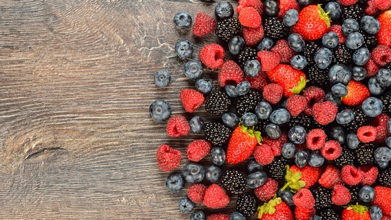 Verschiedene Beeren liegen auf einem Holztisch. © Colourbox Foto: Olga Vasilyeva