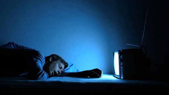 Ein Mann  schläft vor einem Fernseher ©  photocase.de Foto: kallejipp