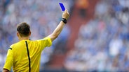 Ein Schiedsrichter zeigt eine blaue Karte. © IMAGO / Kolvenbach 