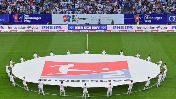 Ein Banner der 2. Bundesliga wird auf dem Rasen im Volksparkstadion gehalten. © Witters 