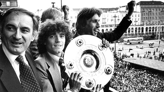 Der HSV feiert die Meisterschaft 1979: Links Coach Branco Zebec, Kevin Keegan mit der Schale und Manfred Kaltz. © picture-alliance / dpa 