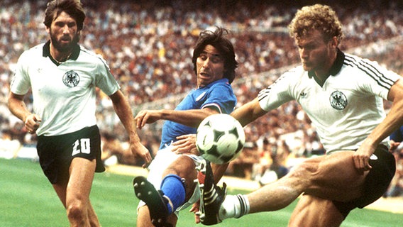 WM-Finale 1982: Manfred Kaltz (l.) und Hans-Peter Briegel (r.) im Zweikampf mit Italiens Stürmer Bruno Conti. © picture-alliance / dpa 