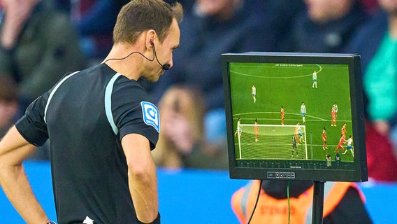 Schiedsrichter Bastian Dankert begutachtet eine strittige Szene am Monitor © IMAGO/ActionPictures 