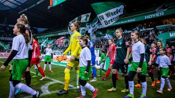 Die Spielerinnen von Werder Bremen und dem SC Freiburg laufen ein. © IMAGO/foto2press 
