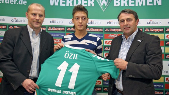 Werder-Trainer Thomas Schaaf (l.) mit Neuzugang Mesut Özil und Manager Klaus Allofs (r.) © dpa 
