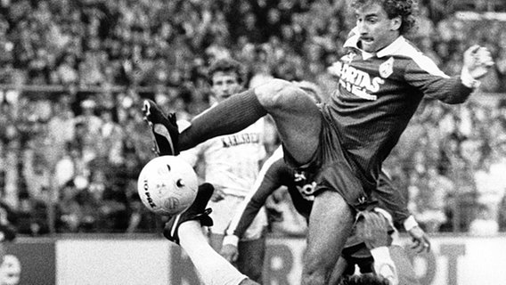 Werder-Torjäger Rudi Völler (o.) im Zweikampf mit dem am Boden liegenden Homburger Abwehrspieler Reinhard Brendel am 8.5.1987 © picture-alliance / dpa 