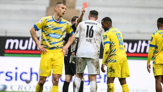 Schiedsrichter Florian Lechner (2.v.l.) verweist Braunschweigs Torhüter Jasmin Fejzic mit einer Gelb-Roten Karte des Platzes. © picture alliance/dpa | Hasan Bratic 