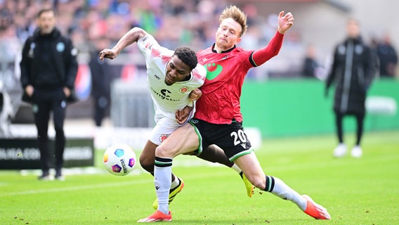 St. Paulis Oladapo Afolayan (l.) und Hannovers Jannik Dehm kämpfen um den Ball. © Witters/LeonieHorky 