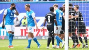 Rostocks Spieler sind enttäuscht, während im Magdeburgs Spieler einen Treffer bejubeln. © IMAGO / Jan Huebner 