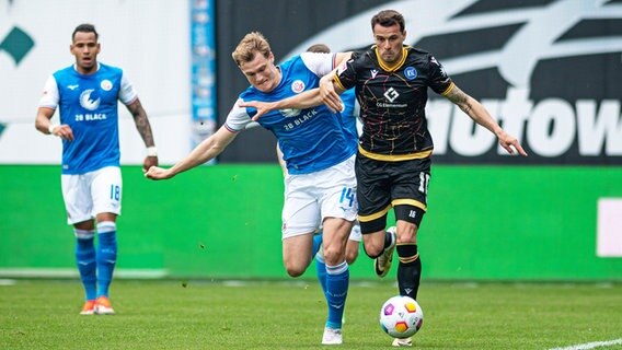 Rostocks Svante Ingelsson (l.) und Karlsruhes Philip Heise kämpfen um den Ball. © IMAGO / Fotostand 